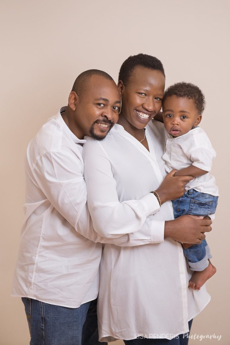 Brian, Manka and their son together, all dressed in white.
